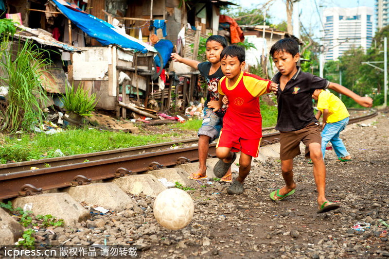 Los niños jugaban fútbol al lado del ferrocarril 一群男孩在铁轨旁踢足球。